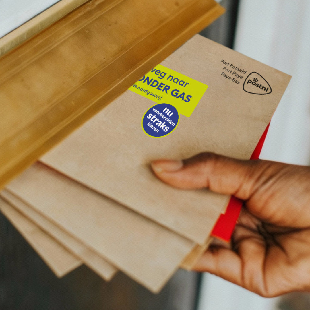 postbode stopt enveloppen in de bus