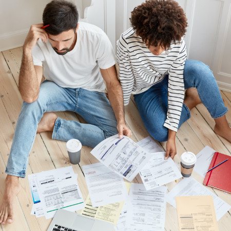 Jong stel kijkt samen naar een stapel paperassen